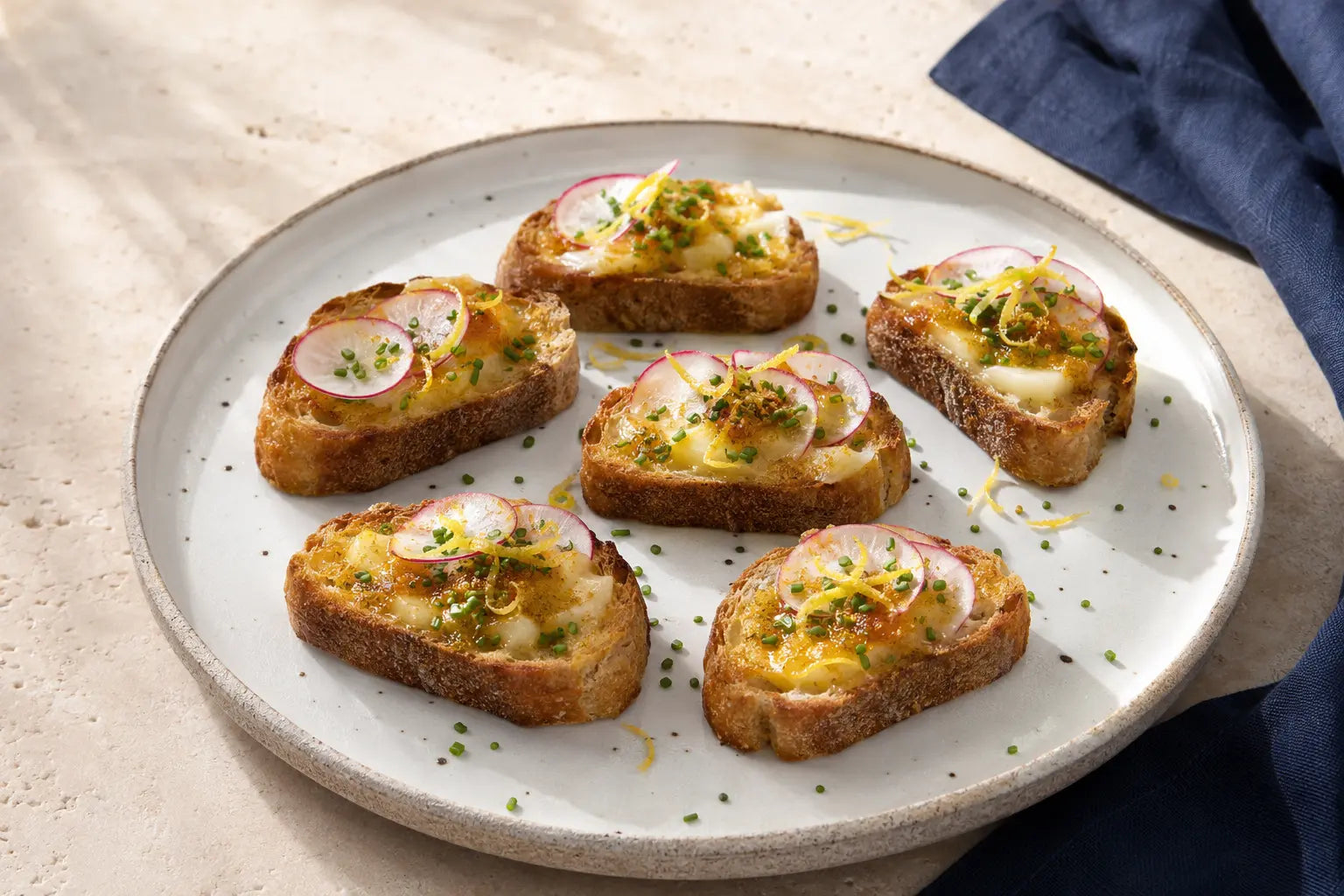 Crostini med bottargasmör, citron, gräslök och tunt skivad rädisa